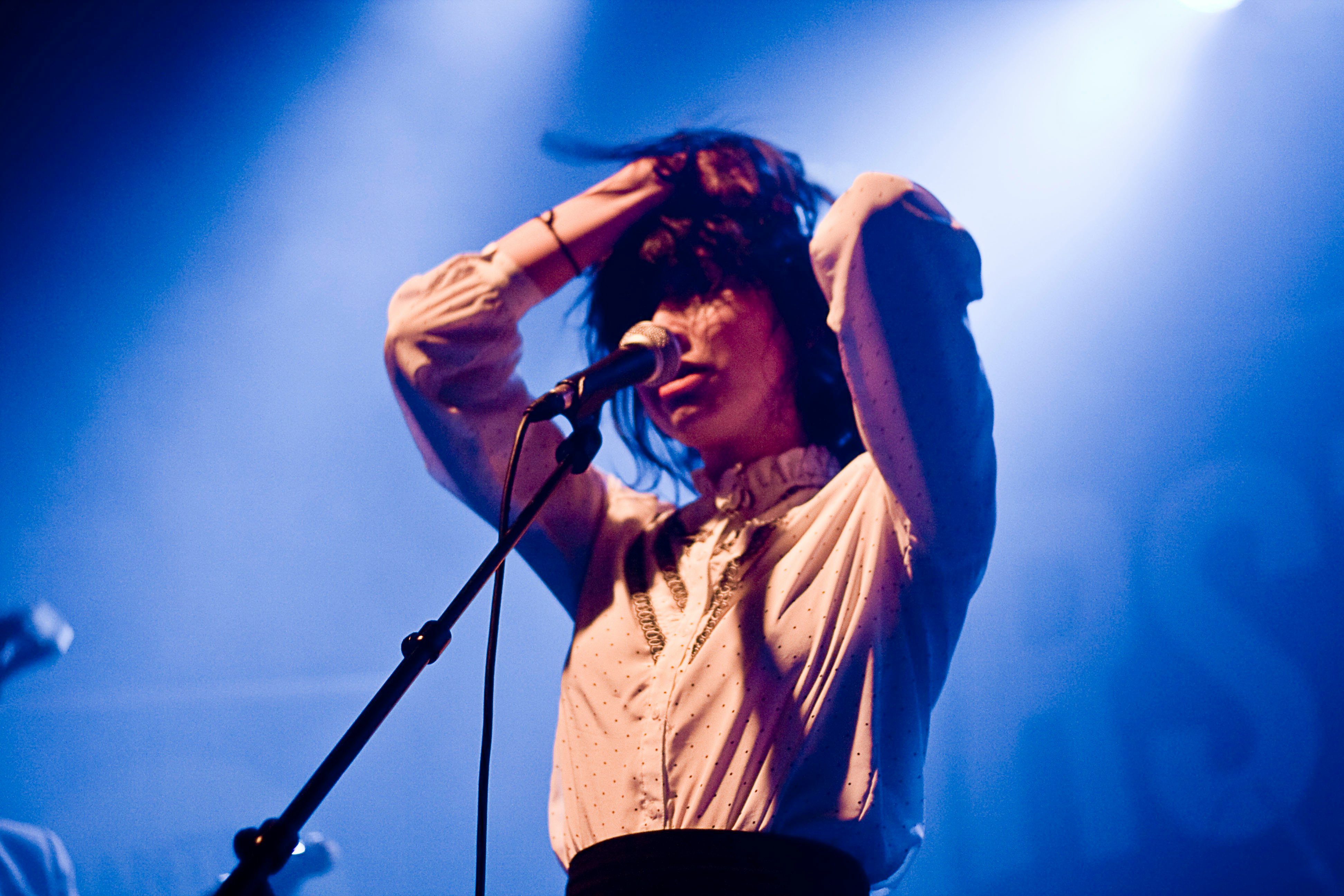 woman holding her hair in front of microphone